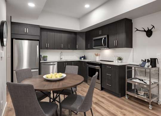 A modern kitchen with a round table and chairs.