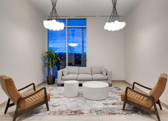 A living room with a large window, a sofa, a chair, a table, and a rug.