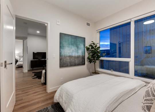 A bedroom with a large bed and a painting on the wall.