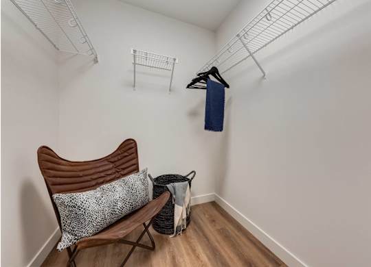 A chair with a pillow and a bag on the floor.