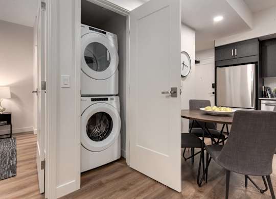 A modern laundry room with a washer and dryer built into the wall.