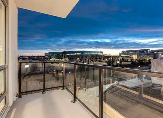 A balcony with a view of a cityscape at dusk.