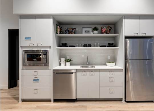 A modern kitchen with a refrigerator, oven, and sink.