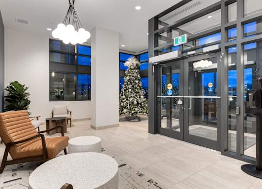 A modern waiting area with a chair, table, and a tree.