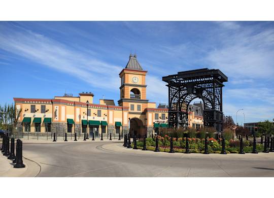 A large building with a clock tower and a large archway in front.