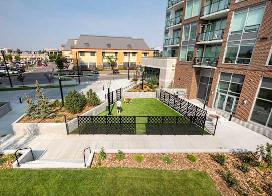 A modern building with a green space in front.