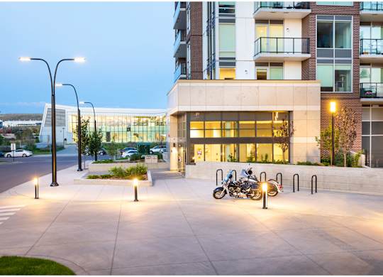 A modern building with a parking area in front.