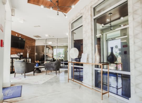 the lobby of a condo with glass doors and furniture at Canalside, Augusta, GA