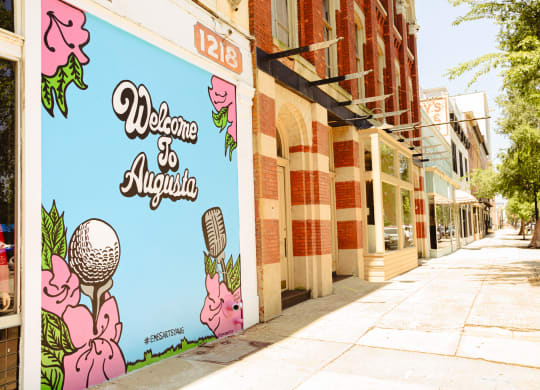 a mural on the side of a building that reads welcome at Canalside, Augusta, GA