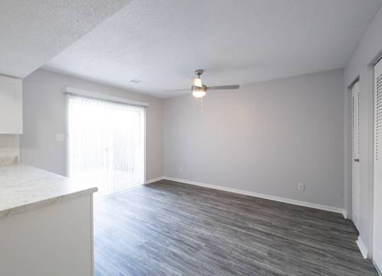 A room with a ceiling fan and a window.