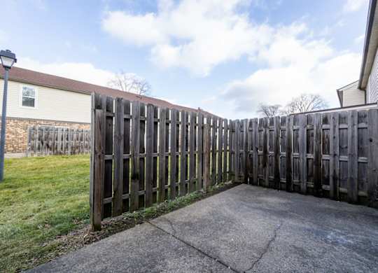 A wooden fence surrounds a concrete area.