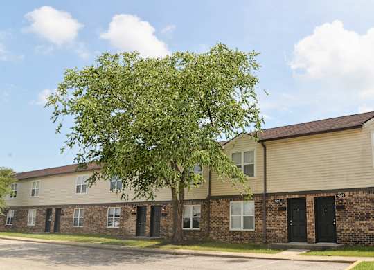 Apartment building with a tree in front of it.