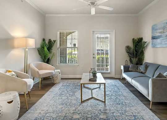 A living room with a grey couch, a coffee table, a chair, a floor lamp, and a painting on the wall.