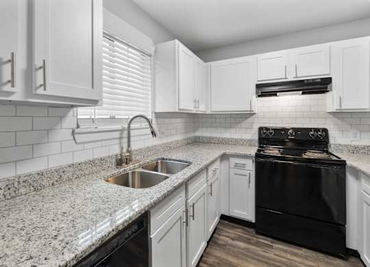 A kitchen with white cabinets and a black stove top oven.