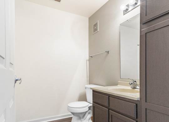 Bathroom with wood style flooring and dark vanity at Northampton Village Apartments, Indianapolis, Indiana