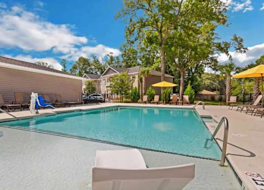 A swimming pool with a white chair and a yellow umbrella.
