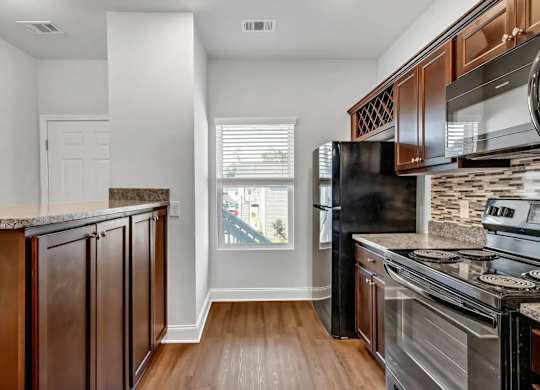 A kitchen with dark wood cabinets and stainless steel appliances.