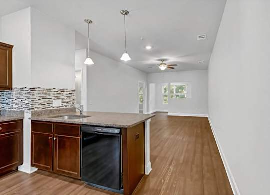 A kitchen with wooden cabinets and a black dishwasher.