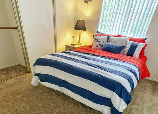 a bedroom with a bed with a striped comforter