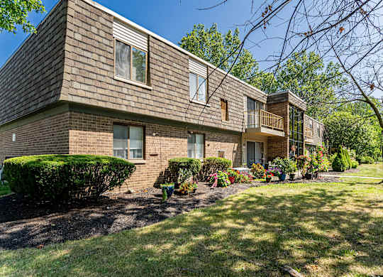 A row of houses with green lawns in front.