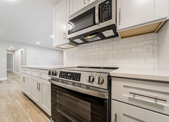 A modern kitchen with a stainless steel oven and microwave.