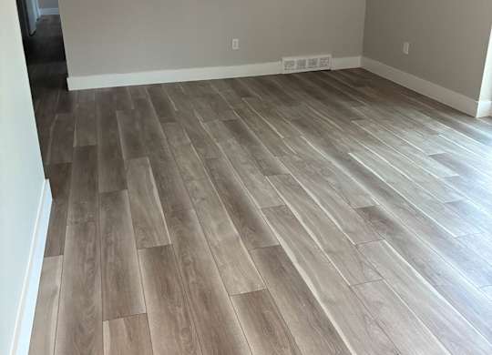 A room with a wood floor and a white wall.