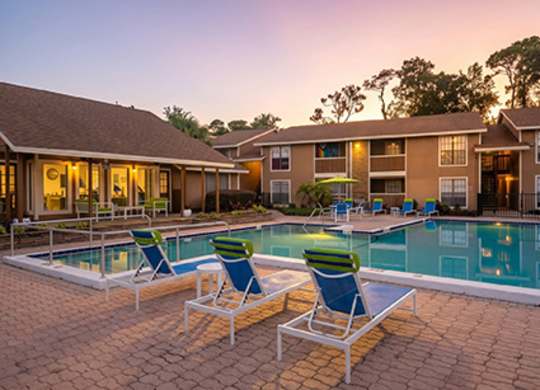 A poolside area with lounge chairs and a swimming pool.