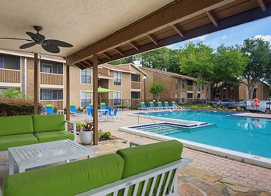 A patio with a pool and a ceiling fan.