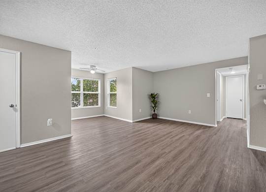 A room with wooden flooring and white walls.