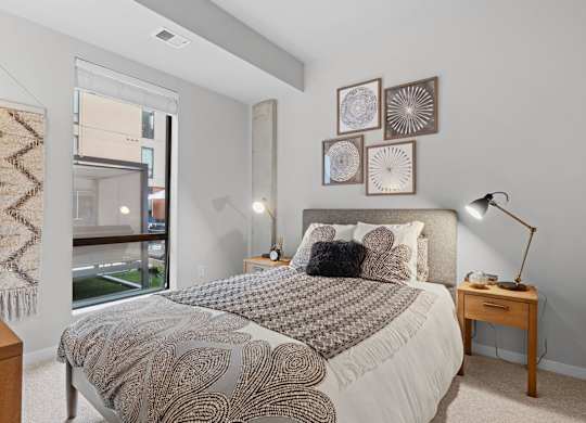 A bedroom with a large bed and a window overlooking a balcony.