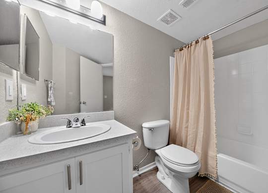 A bathroom with a toilet, sink, and bathtub.