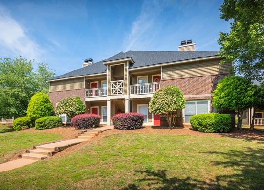 Exterior Of Apartment Homes With Lush Landscaping In Front