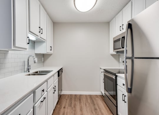 Upgraded Kitchen with White Cabinetry and Stainless Steel Appliances