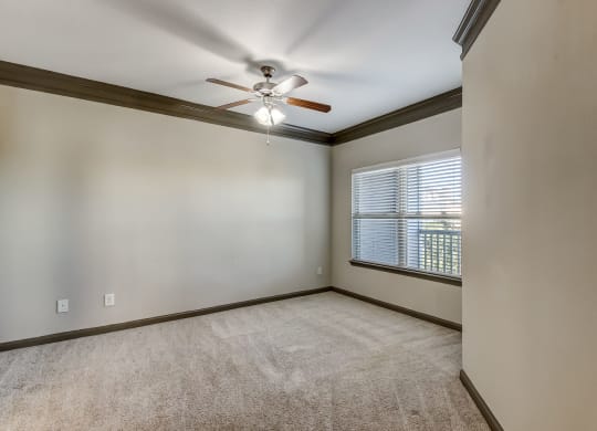 Spacious Carpeted Bedroom With Ceiling Fan