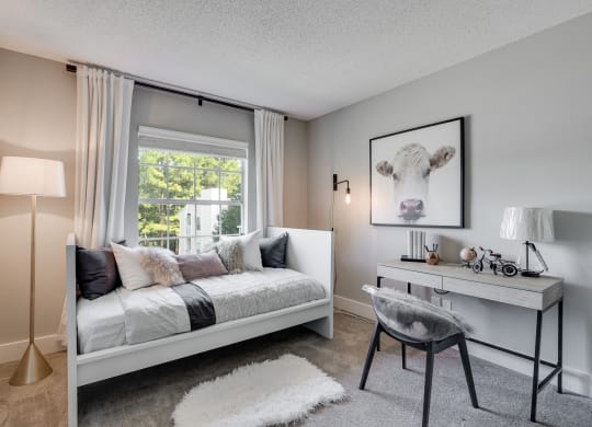 Carpeted Second Bedroom With Large Window That Lets In Lots Of Natural Light