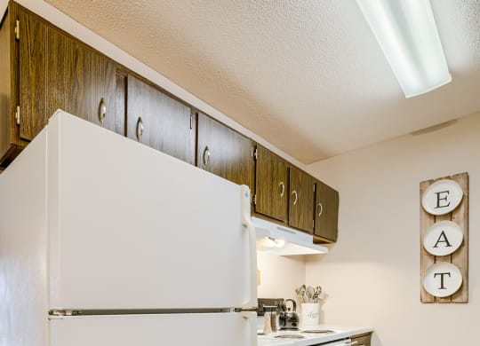a kitchen with white appliances and a refrigerator