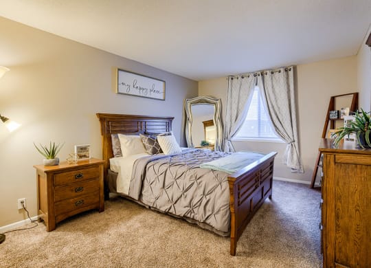 a bedroom with a bed and a dresser and a window