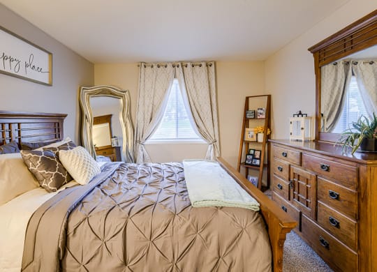 a bedroom with a bed and a dresser and a window