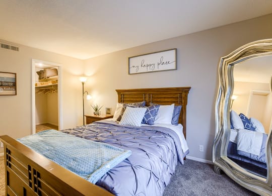 a bedroom with a large bed and a mirror
