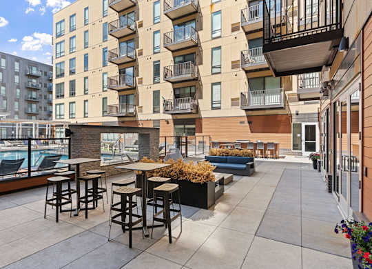 A patio with a table and chairs is surrounded by apartment buildings.
