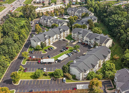 A bird's eye view of a residential area with houses and a parking lot.