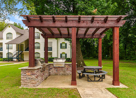 A wooden pergola with a picnic table underneath it.
