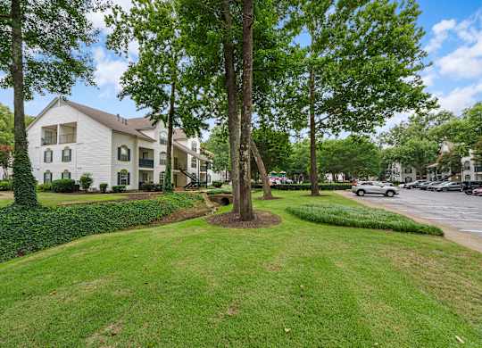 Lush grass and tree area in front of an apartment building