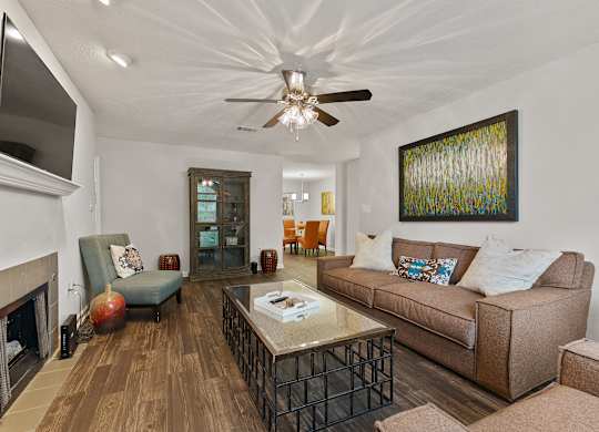 A living room with a brown couch and a fireplace.