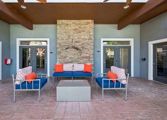 A stone pillar is in the middle of a room with two couches and a bench.