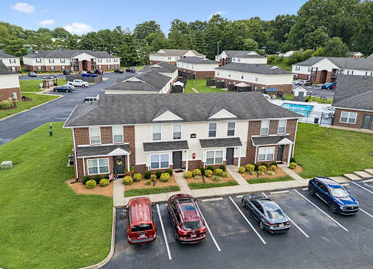 A parking lot with cars and apartment buildings in the background.