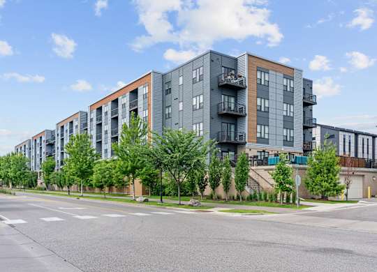 Apartment buildings with balconies line a street.