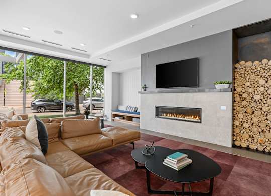 A modern living room with a fireplace and a large window.