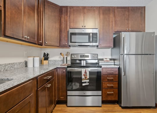Kitchen with Dark Brown Cabinetry and Stainless Steel Appliances