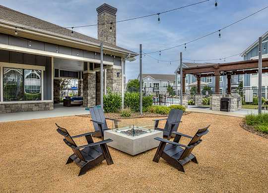 A patio with two chairs and a table in front of a house.